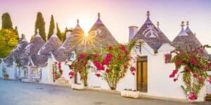 White huts with pink flowers in Apulia, Italy