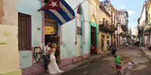 Couple under Cuban Flag in streets of Havana, Cuba