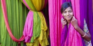 Woman in a Sari factory surrounded by colorful cloths