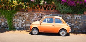 Fiat on flower-lined street in Italy