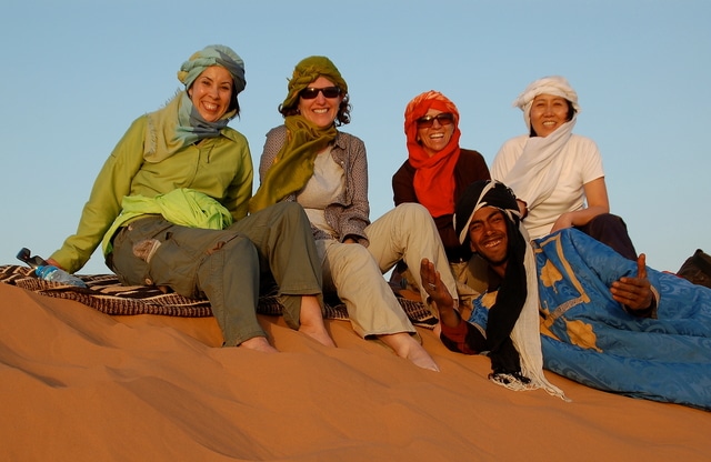 Women on sand dunes in Morocco.