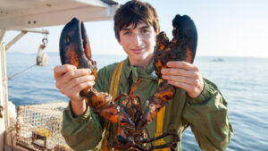 A boy holding a lobster in Nova Scotia