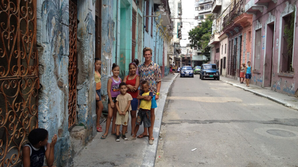 Family in Cuba standing in front walkway of home