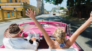 People driving in a convertible in Cuba.