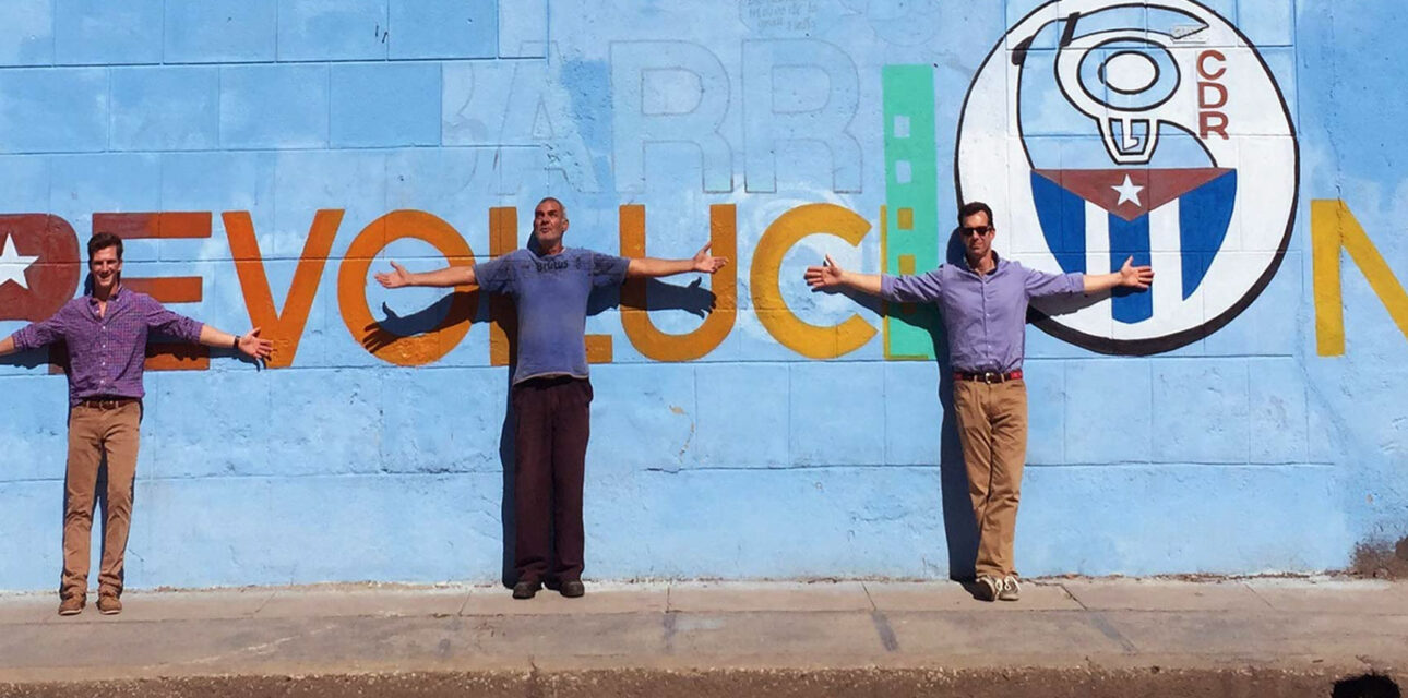 People in front of a sign that says Revolution in cuba.