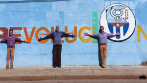 People in front of a sign that says Revolution in cuba.