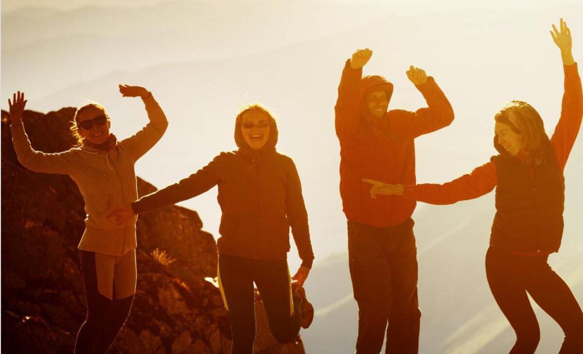 Young people dancing at sunset.