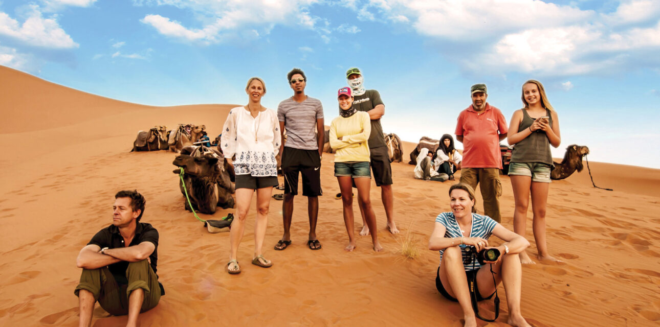 A group of adults standing in the desert.