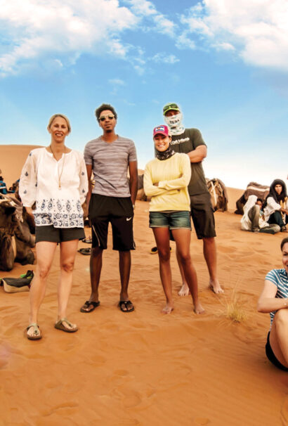 A group of adults standing in the desert.