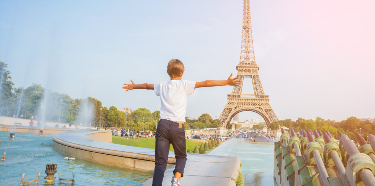 Boy running towards the Eiffel Tower in Paris