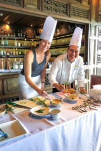 A woman learning from a chef.