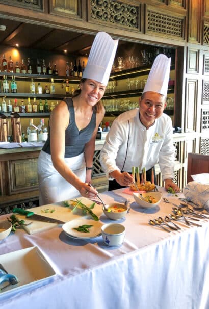 A woman learning from a chef.