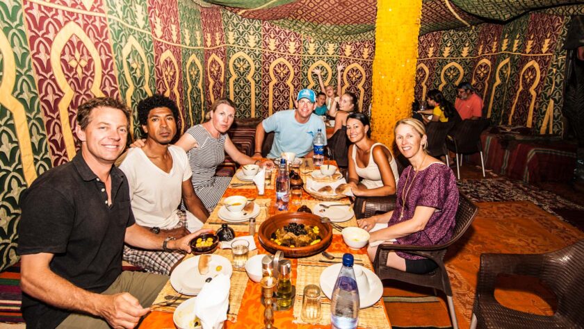 A group of adults eating dinner around a table.