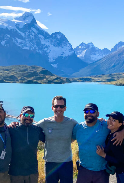 A group shot of tour guides with a mountain landscape backdrop.