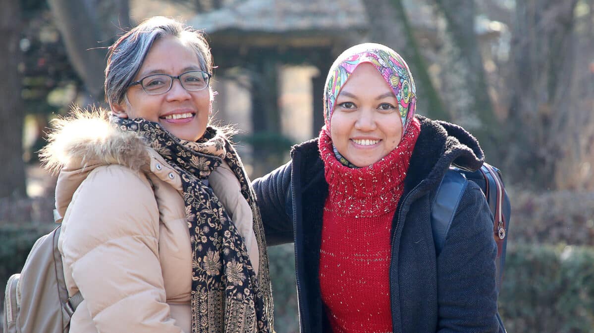 Two young woman smiling in a photo.