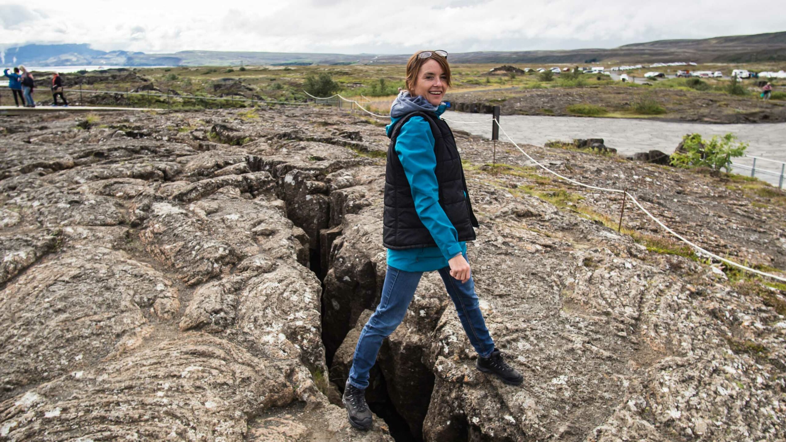 A woman walking between rocks in Iceland.