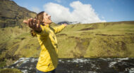 A woman smiling with her arms outstretched.
