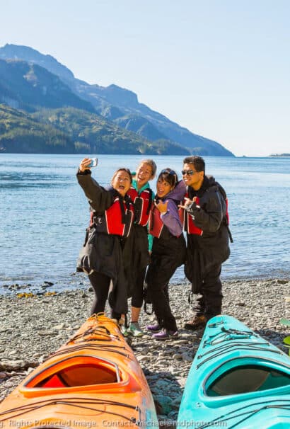 A group of girls posing in front of a lake.