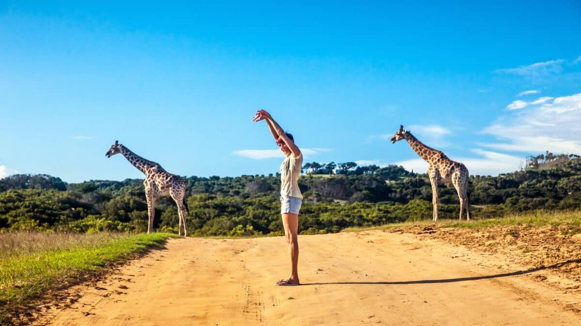 A woman posing with Giraffe.