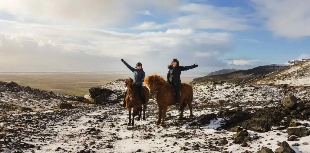 Travelers enjoy a horseback ride through the winter landscape of Iceland