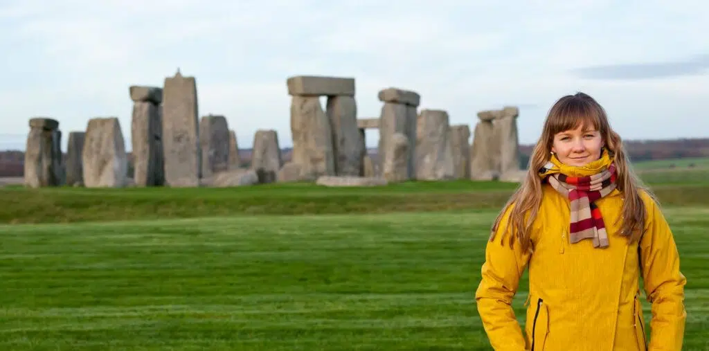 A young traveler stands in front of Stonehenge