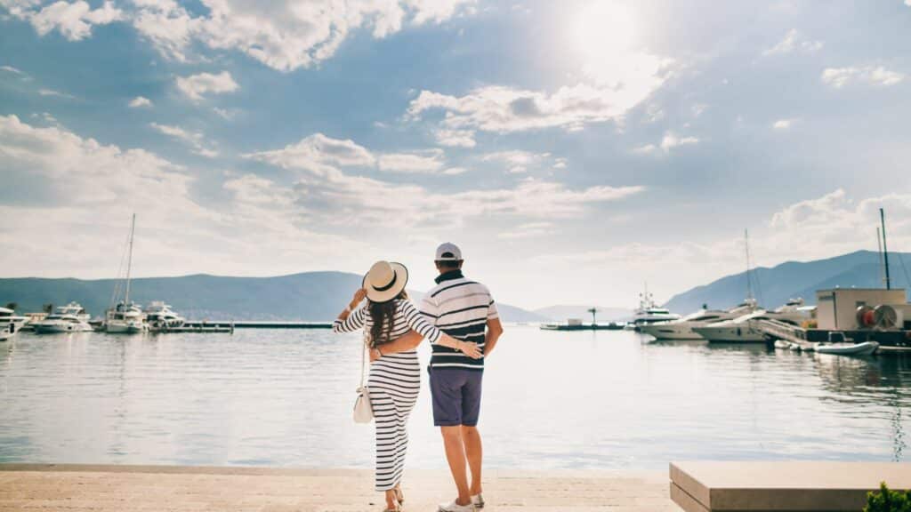 Couple by the water viewing sailboats of the Mediterranean Sea