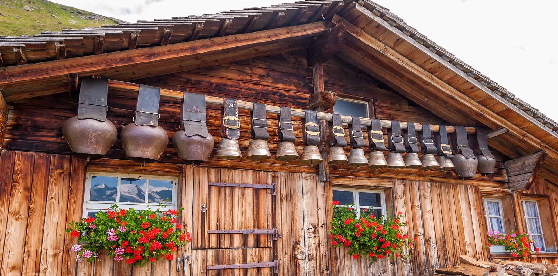 Old cow bells under roof alpine, Swiss Alps