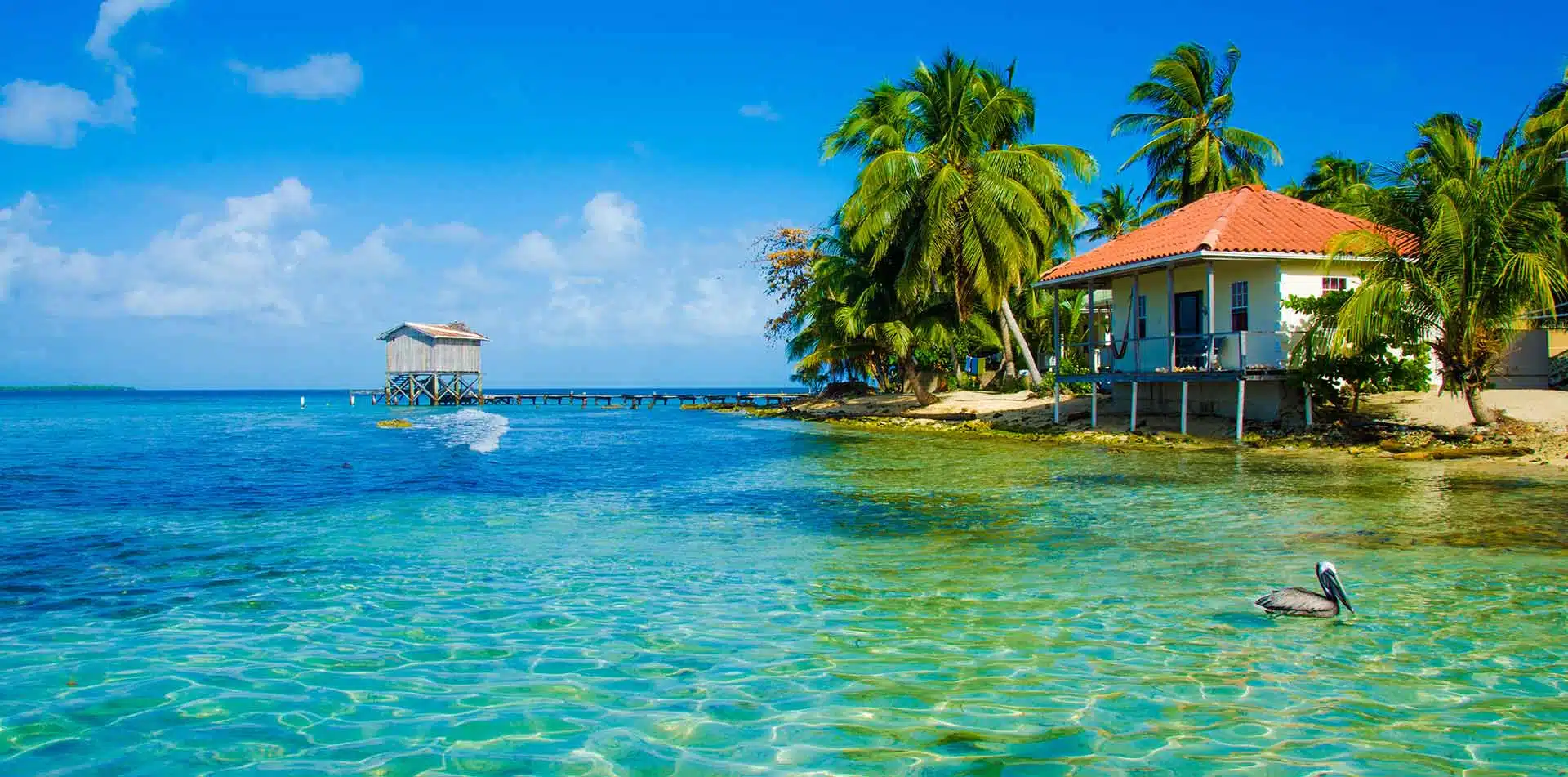 Central America Belize lush tropical island clear blue water beach bungalow scenic dock - luxury vacation destinations