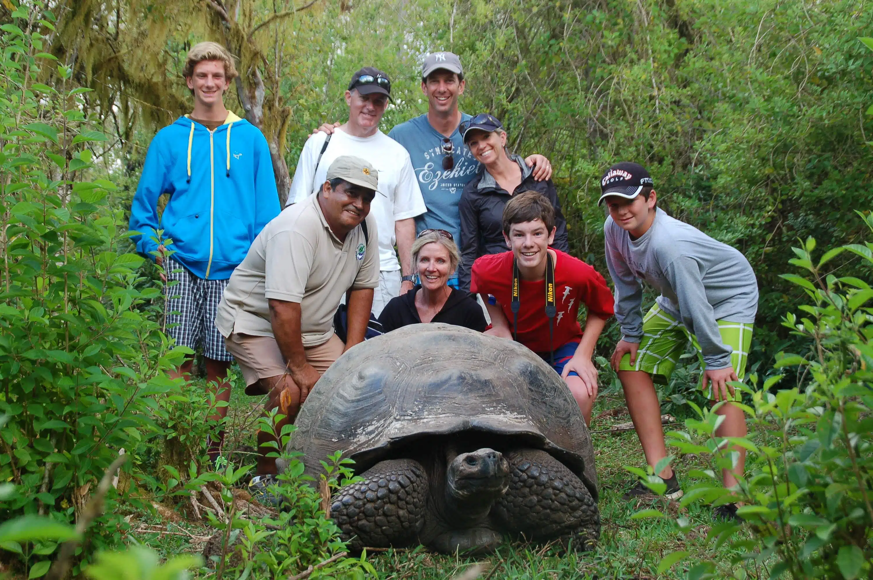 Travelers with giant land tortoise in the Galapagos