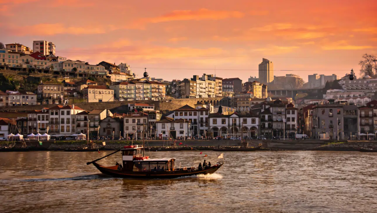 Sunset Rabelo boat in front of Porto skyline, Portugal