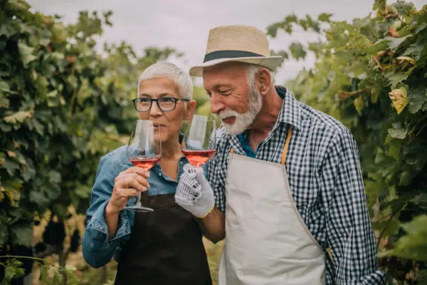 A traveler sips wine in a Portuguese vineyard with a local wine maker