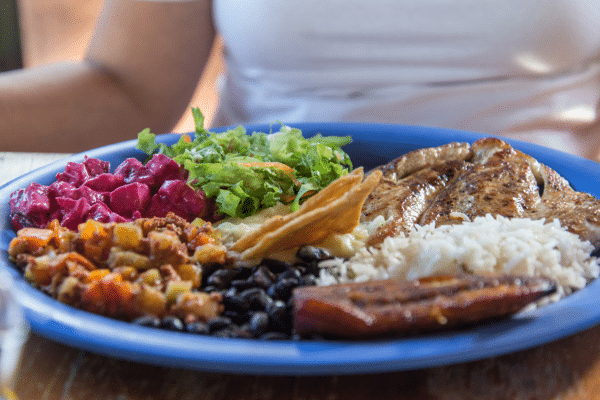 Traveler enjoying a colorful plate of Casado in costa rica