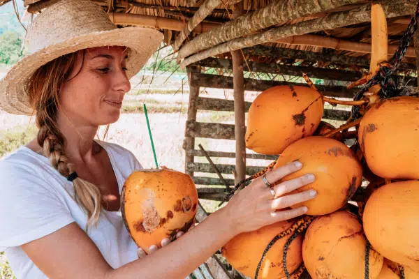 Woman drinking from coconut in street market stall in Costa Rica