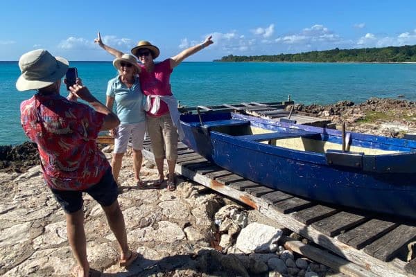 Guests with arms raised taking pictures by the Bay of Pigs in Cuba