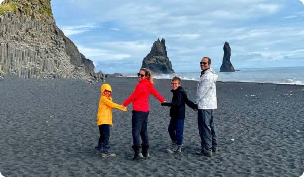 Family walking on Iceland's black sand beach