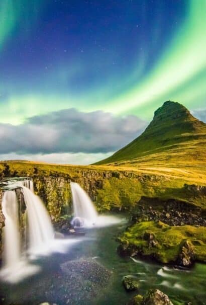 Beautiful Iceland waterfall and volcano landscape with the Aurora Borealis in the background
