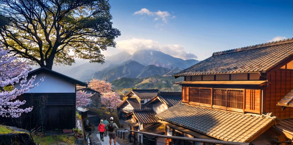 Traditional Japanese village with mountain views and cherry blossoms