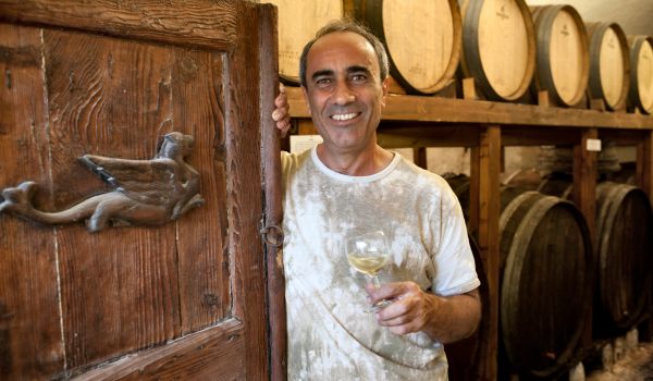 Guide in Greece opening his cellar tour to guests to offer wine