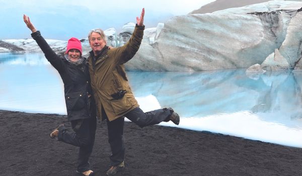 Couple smiling with their hands in the air in Iceland