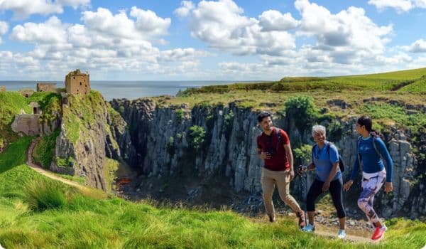 Group walking past ruins in Scotland on a walking tour.