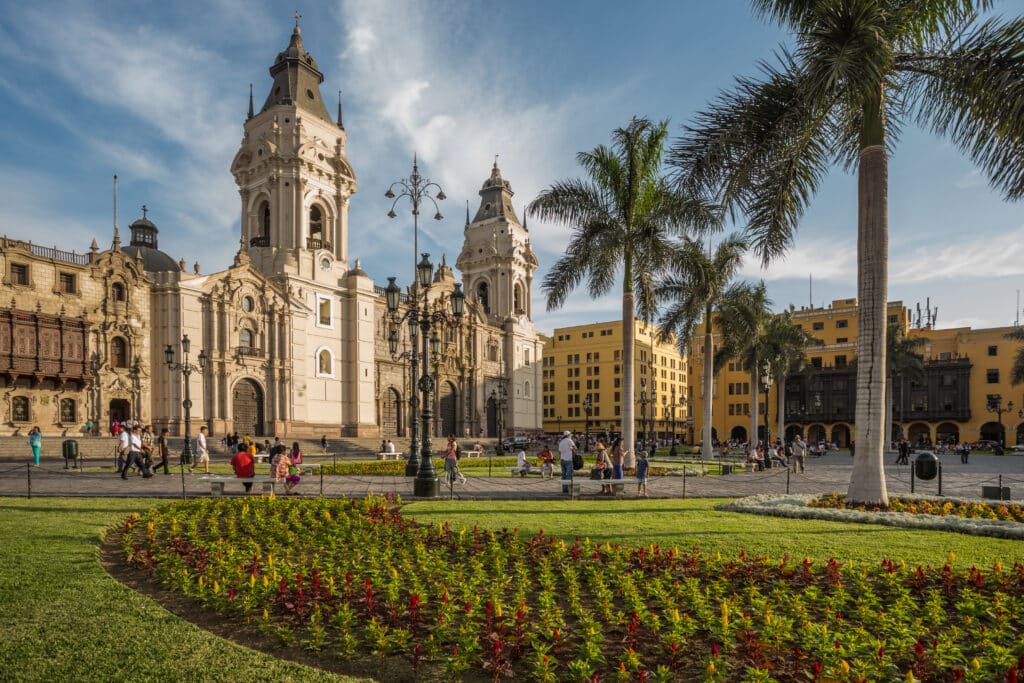 Plaza Mayor and the Cathedral of Lima, Peru, surrounded by palm trees.
