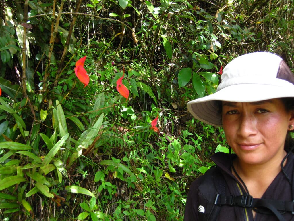 Local guide beside colorful orchids in Peru’s cloud forest.
