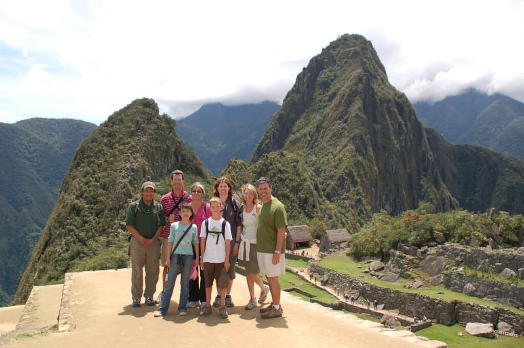 Family and their local guide overlooking the ruins of Machu Picchu, Peru.
