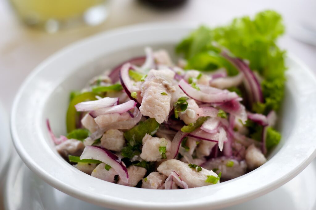 Traditional Peruvian ceviche with fresh fish, red onion, lime, and herbs.

