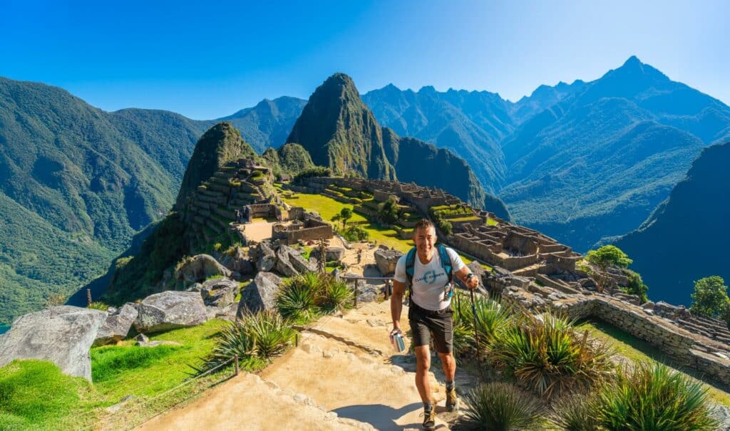 Traveler hiking through the ruins of Machu Picchu in Peru
