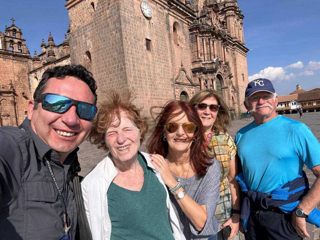 Travelers with their local guide in front of Cusco Cathedral, Peru.
