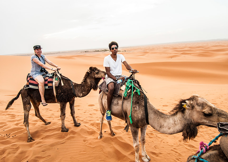 Morocco male traveler riding camel