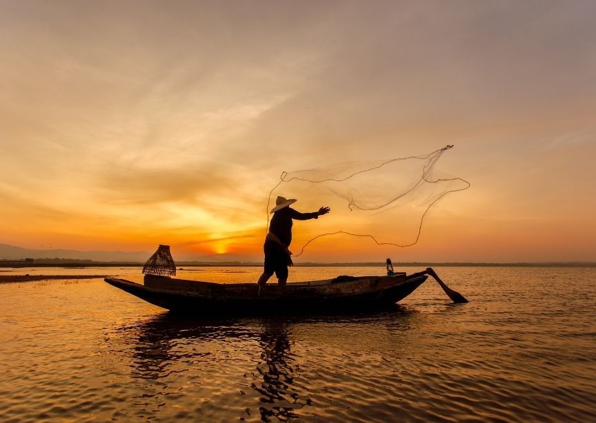 Asia Cambodia Mekong river sunrise fisherman casting net into river water