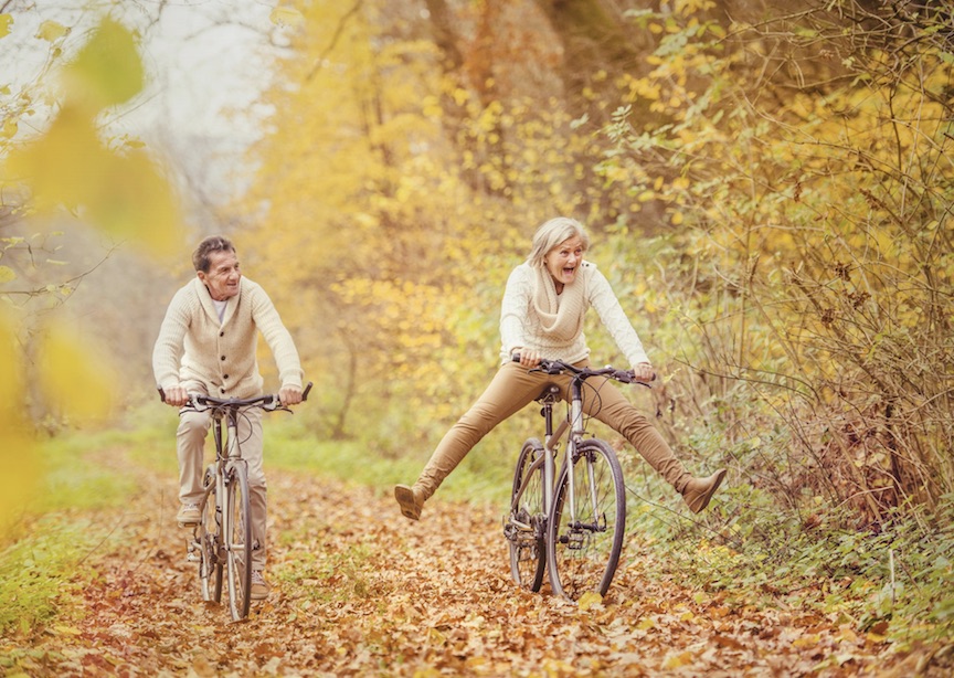 Fall foliage forest happy couple on bikes