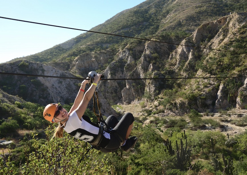 Female traveler ziplining in Costa Rica rainforest